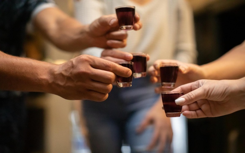 Grupo de amigos brindando con chupitos en una fiesta