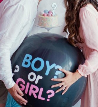 Pareja sujetando un globo negro con el mensaje Boy or Girl en una fiesta de gender reveal