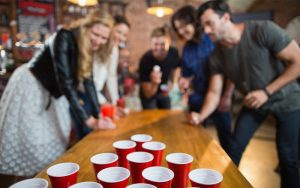 Grupo de amigos jugando al beer pong como uno de los juegos para fiestas más populares