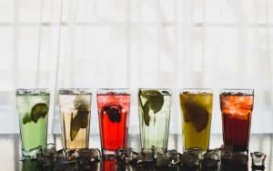 Vasos de bebidas sin alcohol con hielo y frutas para fiestas y eventos