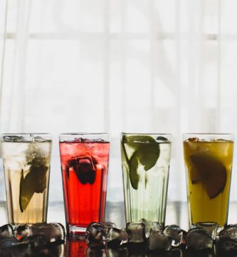 Vasos de bebidas sin alcohol con hielo y frutas para fiestas y eventos