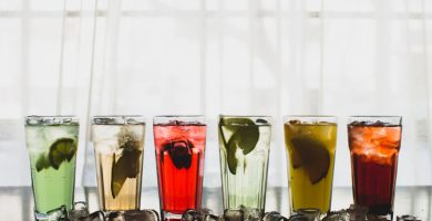 Vasos de bebidas sin alcohol con hielo y frutas para fiestas y eventos