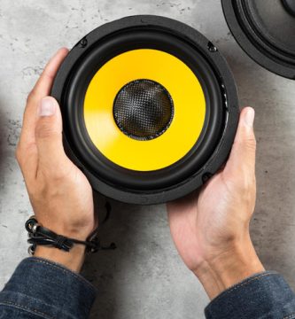 Manos sosteniendo un altavoz profesional como parte de un equipo de sonido para eventos
