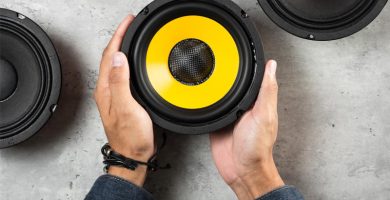 Manos sosteniendo un altavoz profesional como parte de un equipo de sonido para eventos