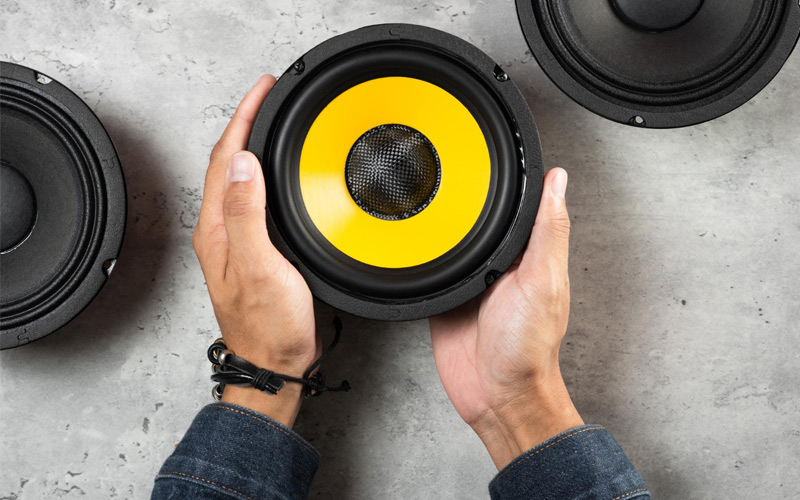 Manos sosteniendo un altavoz profesional como parte de un equipo de sonido para eventos