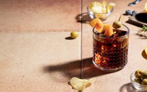 Combinado con ron servido con hielo, piel de naranja y aceituna junto a varios ingredientes